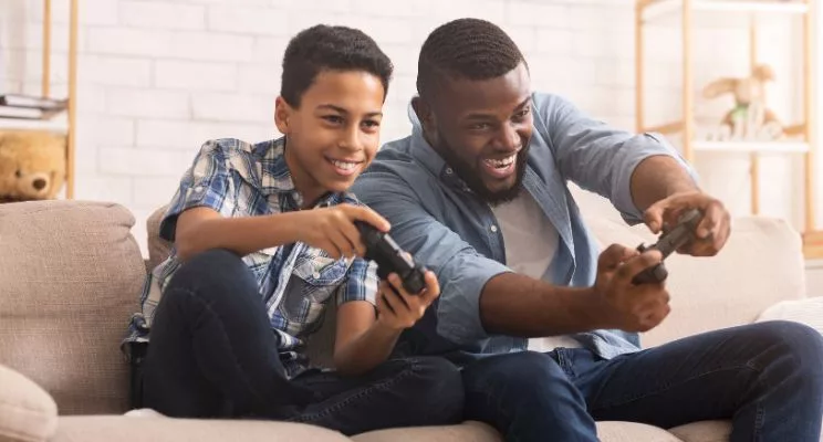 Father and son playing video games on the couch