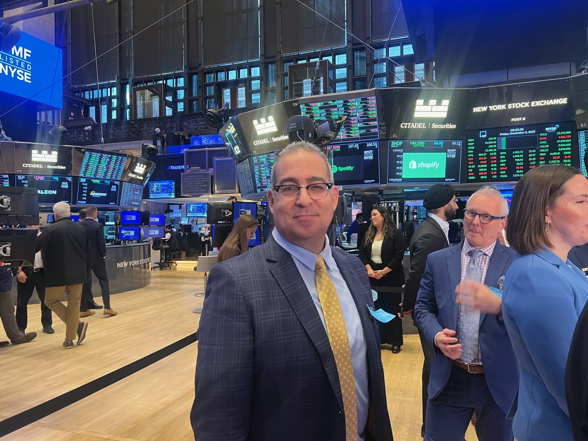 Advisor in a suit and gold tie on the trading floor of the New York Stock Exchange