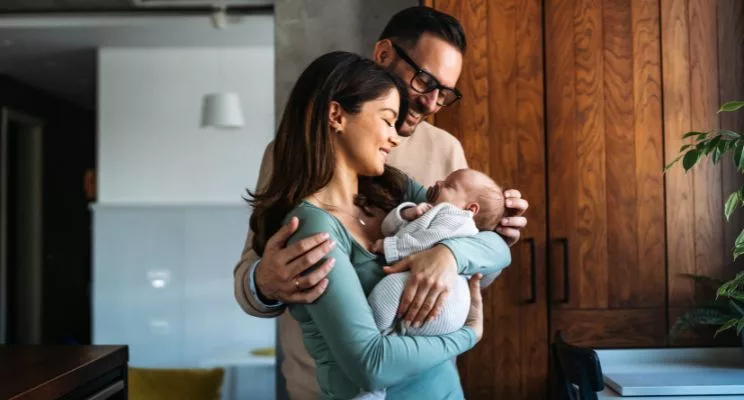 Parents holding their newborn baby at home